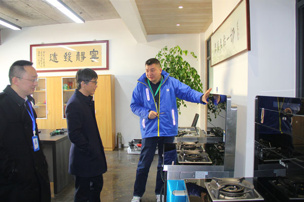 风暴娱乐电器副总裁王春雷为沈建新教授一行人介绍风暴娱乐·AIoT智能集成灶